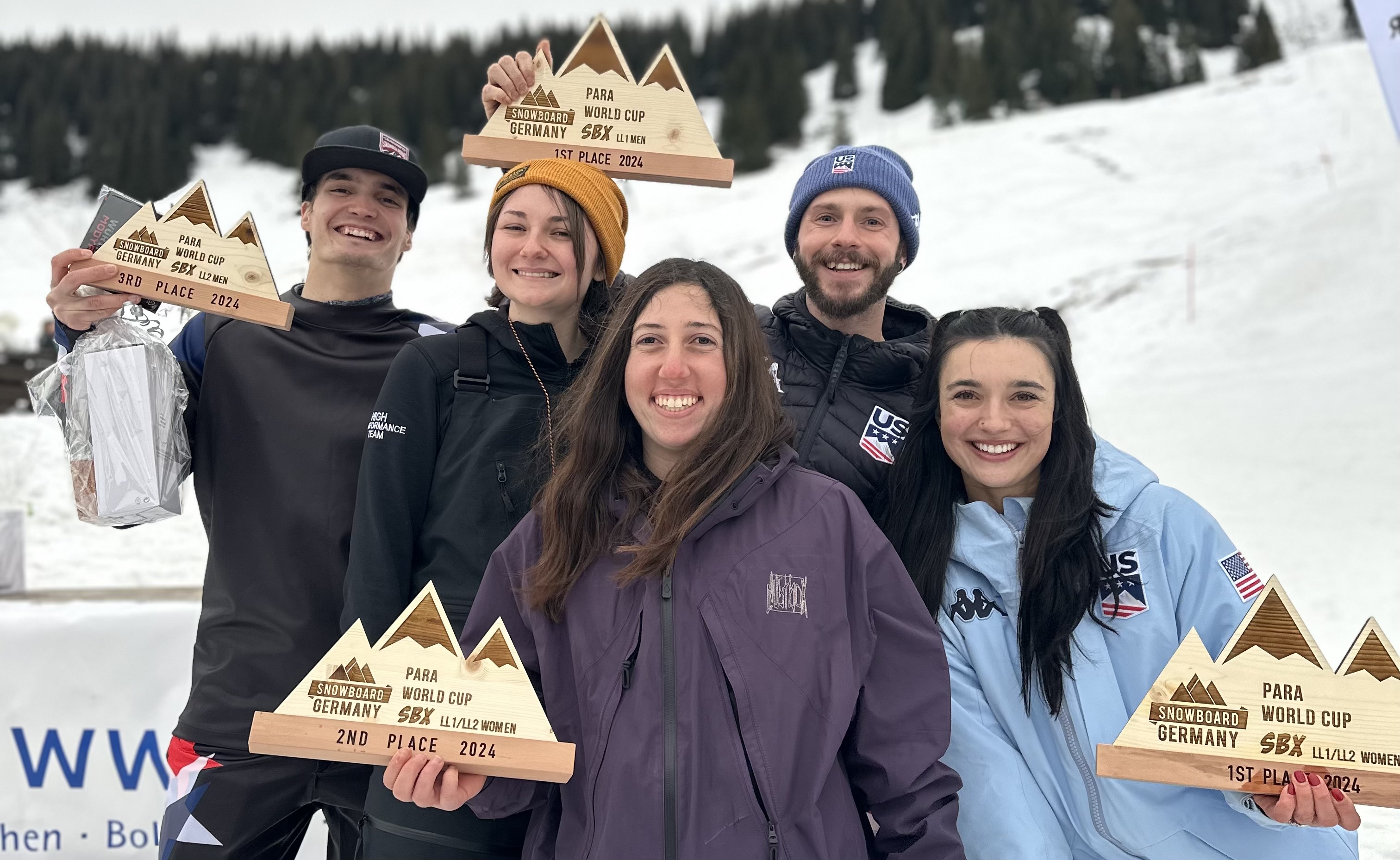 Brenna Huckaby, Kate Delson, Noah Elliott and Zach Miller smile with their awards following the podium ceremony in Grasgehren, Germany