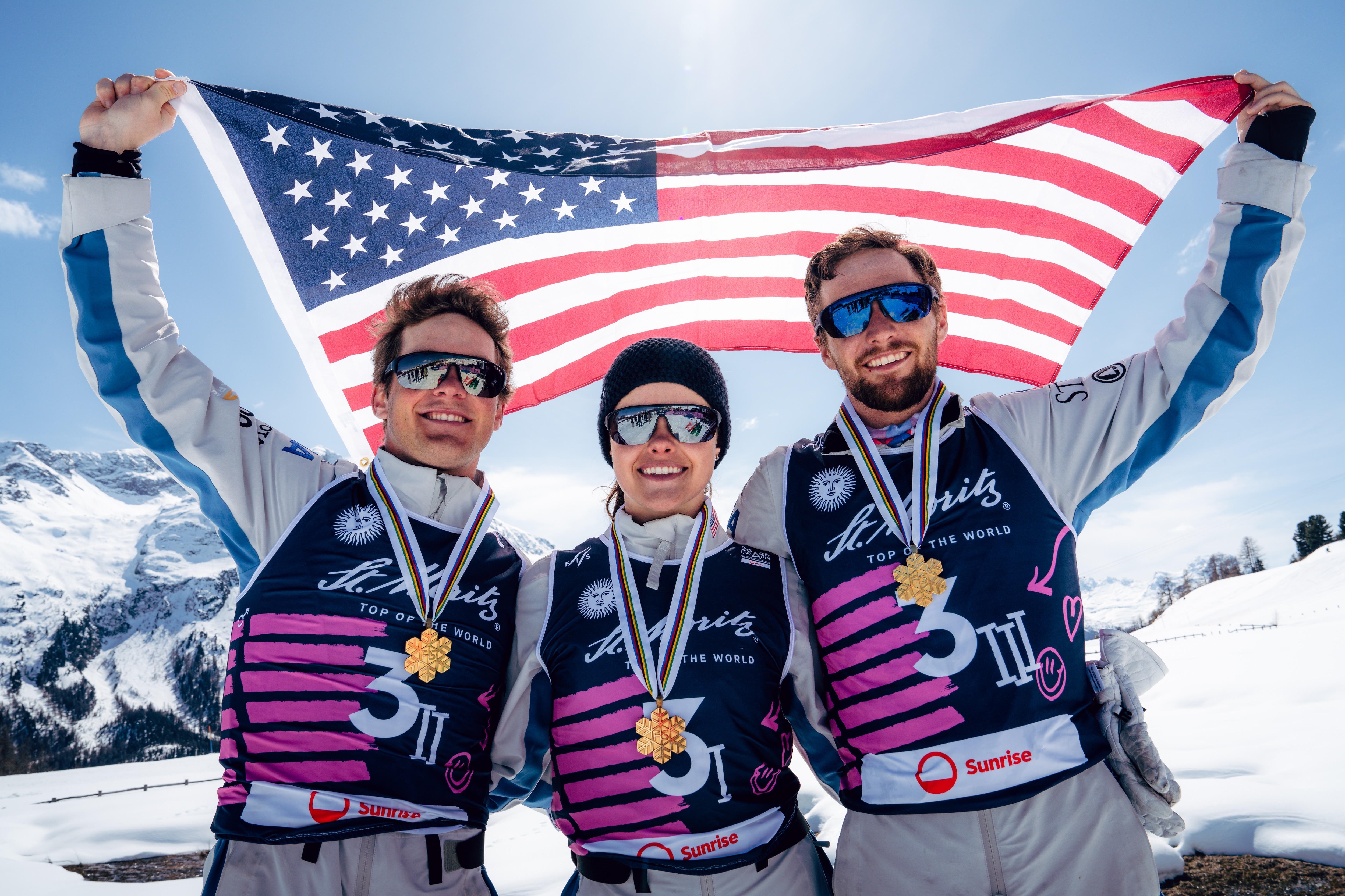 Quinn Dehlinger, Kaila Kuhn and Chris Lillis hold an American flag with their World Championship medals