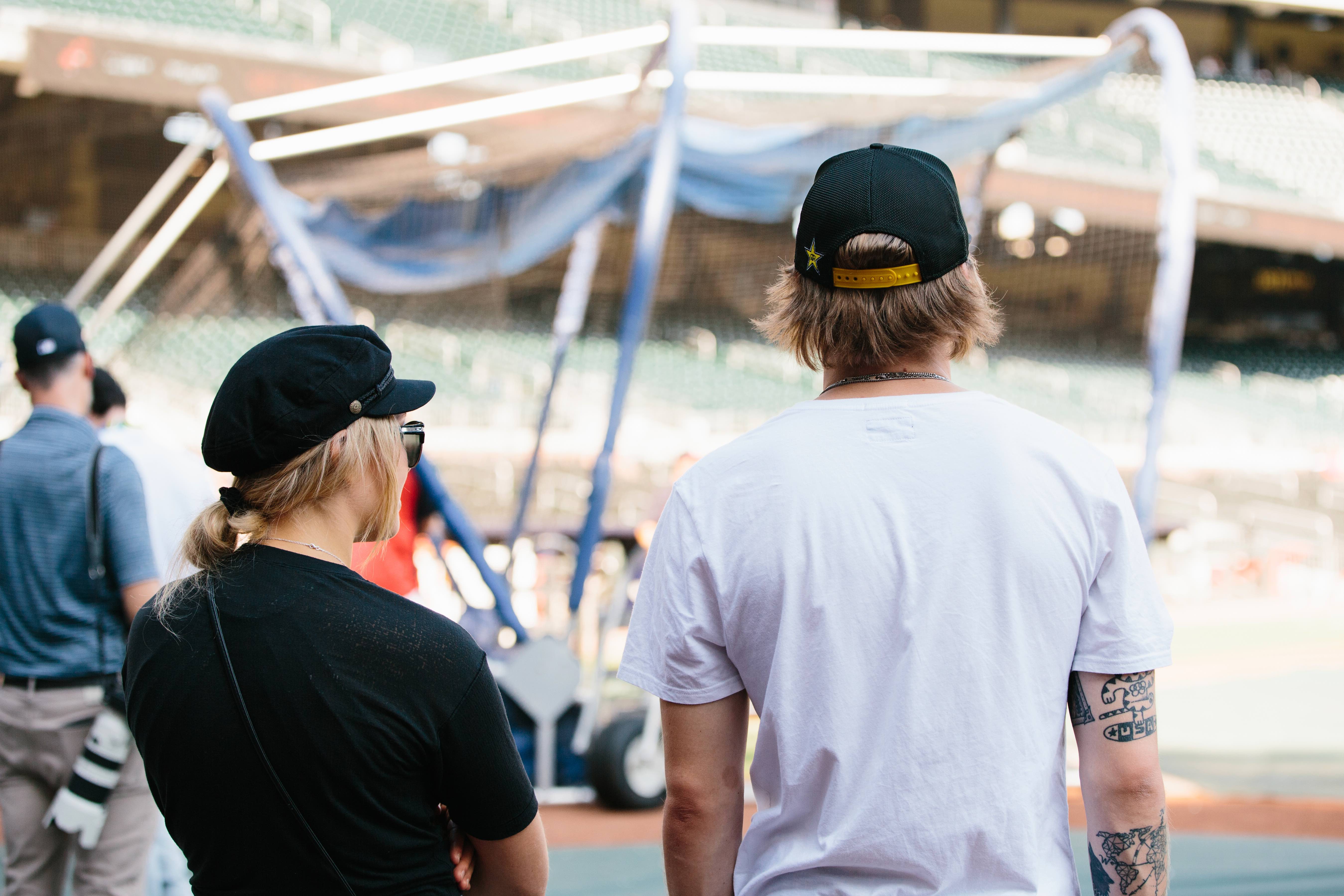 Kyle Mack and Maggie Voisin watching batting practice at the Visa Big Air presented by Land Rover Announcement at SunTrust Park. (U.S. Ski & Snowboard - Sarah Brunson) Maggie, Kyle Batting Practice