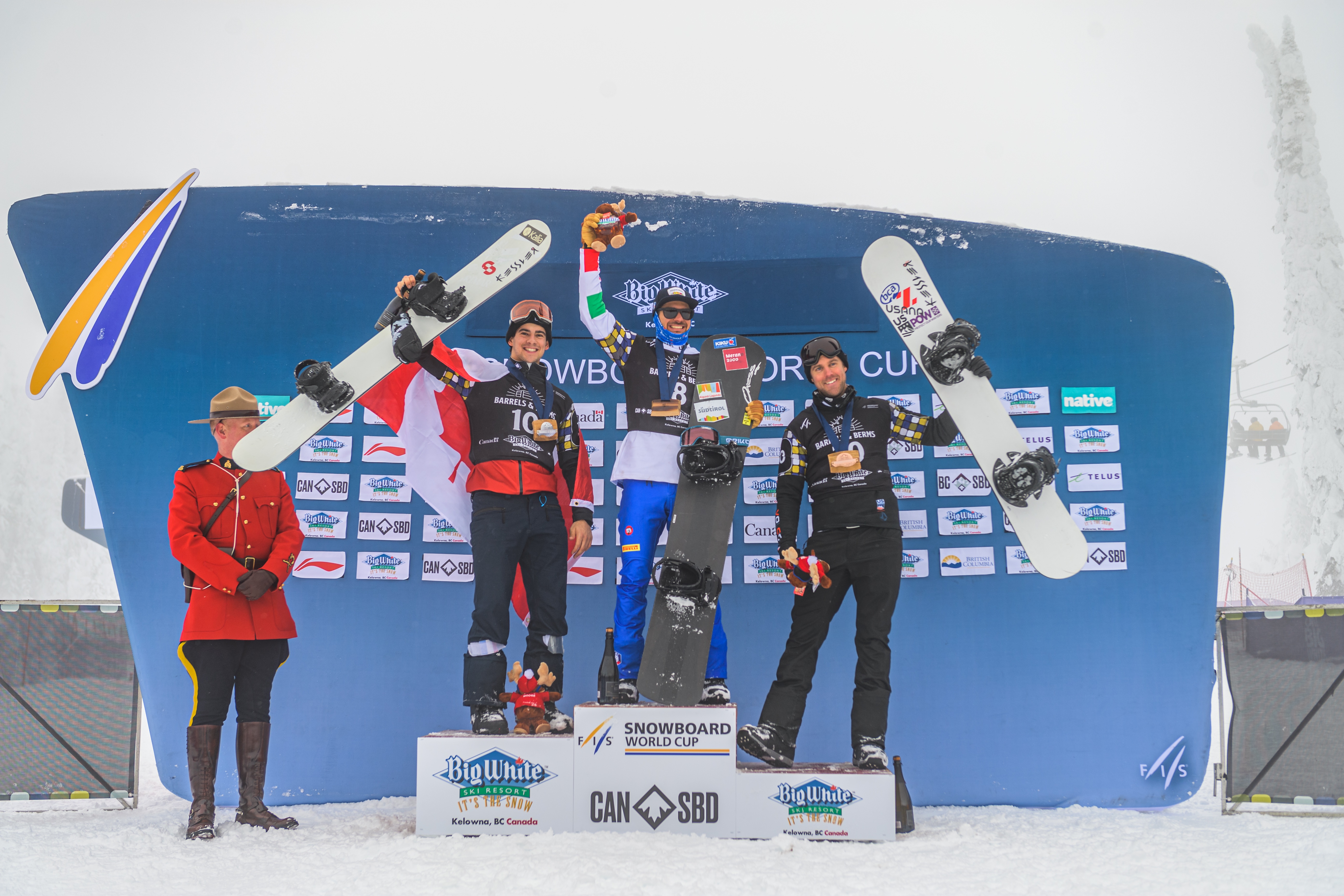 Eliot Grondin (left), Omar Visintin (center), and U.S. Snowboardcross Team member Alex Deibold (right) on the podium at the Big White FIS Snowboardcross World Cup in Canada. (Canada Snowboard) big white podium