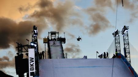 Troy Podmilsak in mid-air during Big Air training at sunset in Chur, Switzerland