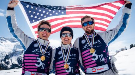 Quinn Dehlinger, Kaila Kuhn and Chris Lillis hold an American flag with their World Championship medals
